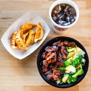a bowl of chicken, broccoli, and fries