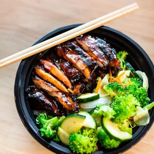 a bowl of food with chopsticks
