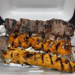 grilled meat and vegetables in a styrofoam container