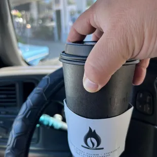 a hand holding a coffee cup