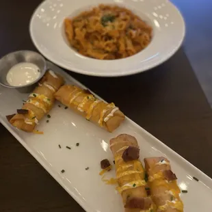 Front: loaded potato egg rolls, back: sausage campanelle