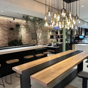 a restaurant with a long wooden table and stools