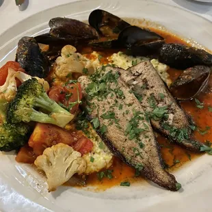 Petrale Sole Special with a spicy tomato sauce, steamed mussels and vegetables served over polenta