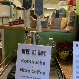 a sign that says if we have kombucha, nitro coffee please ask for assistance not self serve