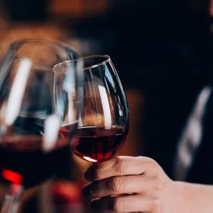 a man holding a glass of red wine