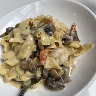 a plate of pasta with shrimp and mushrooms