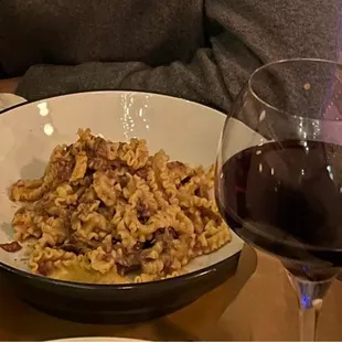 a bowl of pasta and a glass of wine