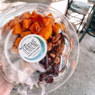a hand holding a container of food