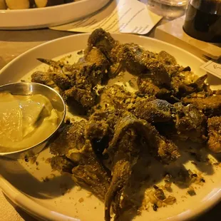 a plate of fried fish with a side of mustard