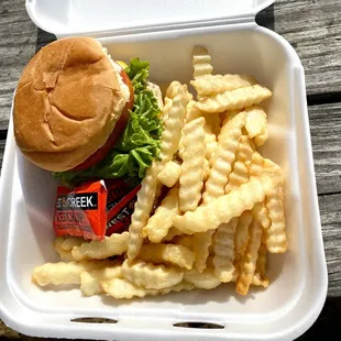 a hamburger and fries in a styrofoam container