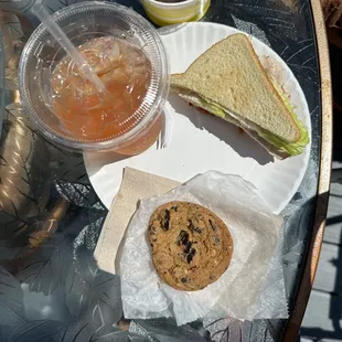 Half of a turkey sandwich, a side of fresh fruit, a delicious chunky chocolate chip cookie and fresh iced tea with a splash of lemonade.