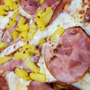 a pizza with pineapples and ham
