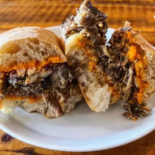 a beef sandwich cut in half on a plate