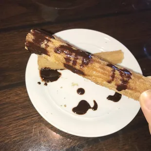 a person holding a piece of food on a plate