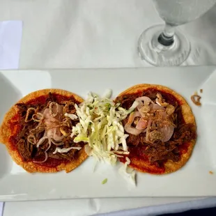 two small pizzas on a white plate