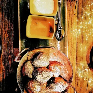 a bowl of powdered sugared doughnuts and butter