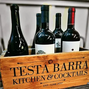 three bottles of wine in a wooden crate