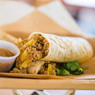 a burrito and dipping sauce