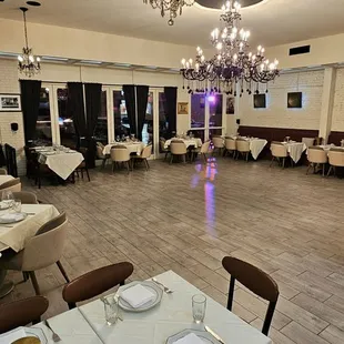 a dining room with tables, chairs, and chandeliers