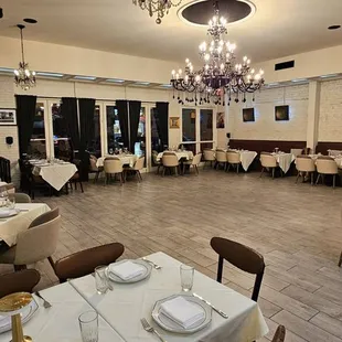a dining room with tables and chairs and a chandelier