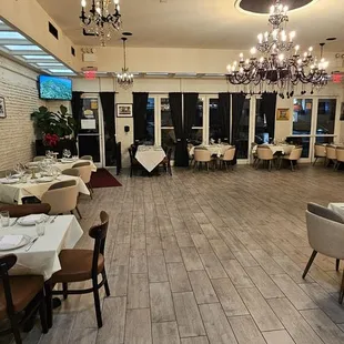 a dining room with tables, chairs, and chandeliers
