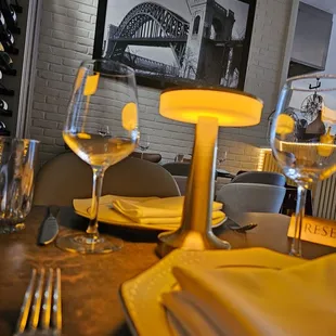 a table setting with wine glasses, plates and utensils