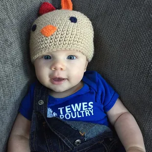 a baby wearing a chicken hat