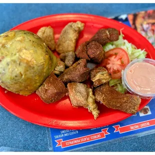 Mofongo with carne frita (fried pork) and salad.