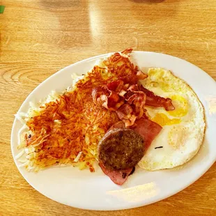 Sampler platter and he choose  sausage, eggs and hash-browns, and out of the picture were two fluffy pancakes.
