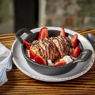 a bowl of ice cream and strawberries