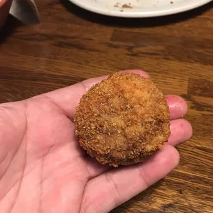 a hand holding a fried chicken nuggies
