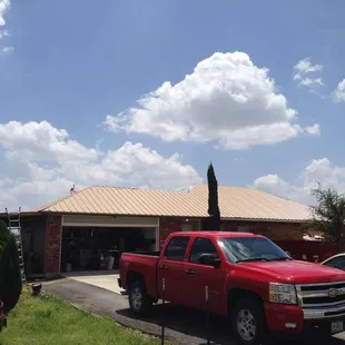a red truck parked in front of a garage