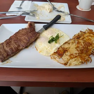 Ribeye steak, eggs and hash brown.
