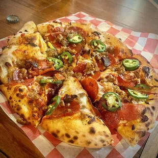 a pizza with pepperoni and jalapenos