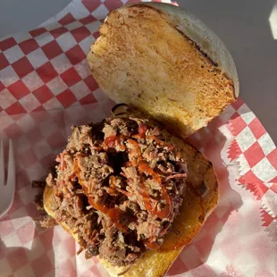Close-up of my sandwich with a drizzle of bbq sauce. Generous amount of meat. It is the BEST slow cooked, smokey flavor brisket in Texas.