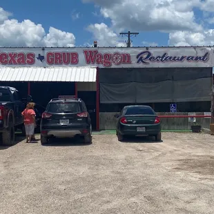 two cars parked in front of a restaurant