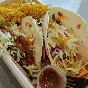 a tray of tacos and rice