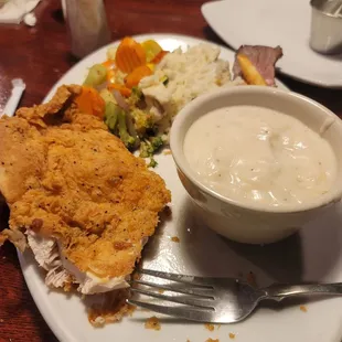 Chicken fried chicken with mashed potatoes and liquid vegetables.