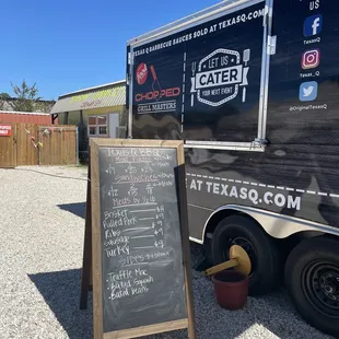 a chalkboard sign outside of a food truck