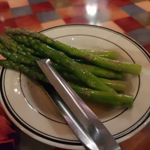 a plate of asparagus and a knife
