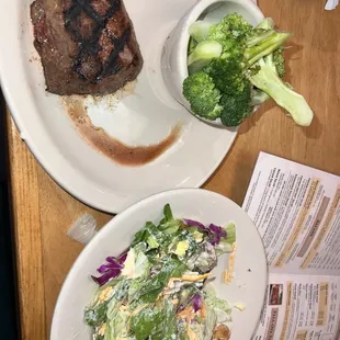 a plate of steak and a salad