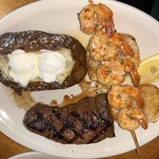 a plate of food with shrimp, steak, and potatoes