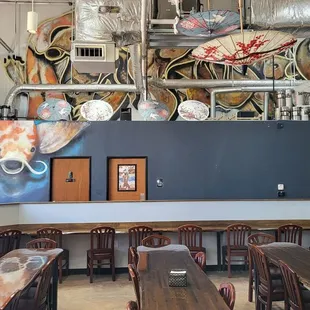 The koi graffiti travels up the wall into a large group of fish near the ceiling.