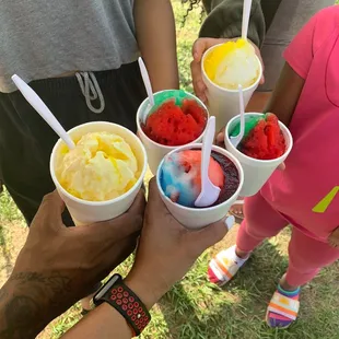 a group of people holding cups of ice cream