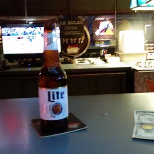 a bottle of lite beer sitting on a counter