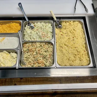 *Delicious BBQ Sides* -BBQ sides including creamy potato salad, tangy coleslaw, tasty pasta salad, and butter, sour cream, and cheese.