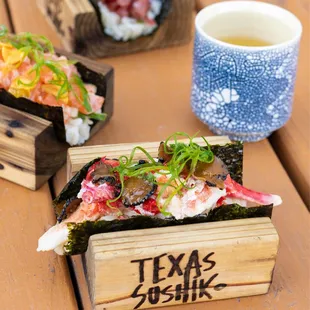 a wooden box with sushi on it