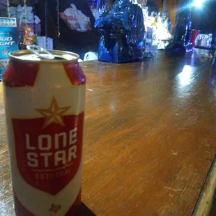 a lone star beer can sitting on a bar