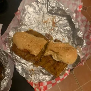 two sandwiches wrapped in tin foil