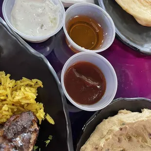 The lamb shank is served with three sources comprised of Tadziki, honey and barbecue.